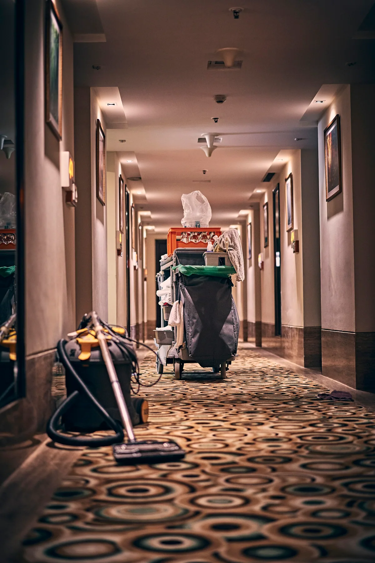 A housekeeping cart in a long hotel corridor