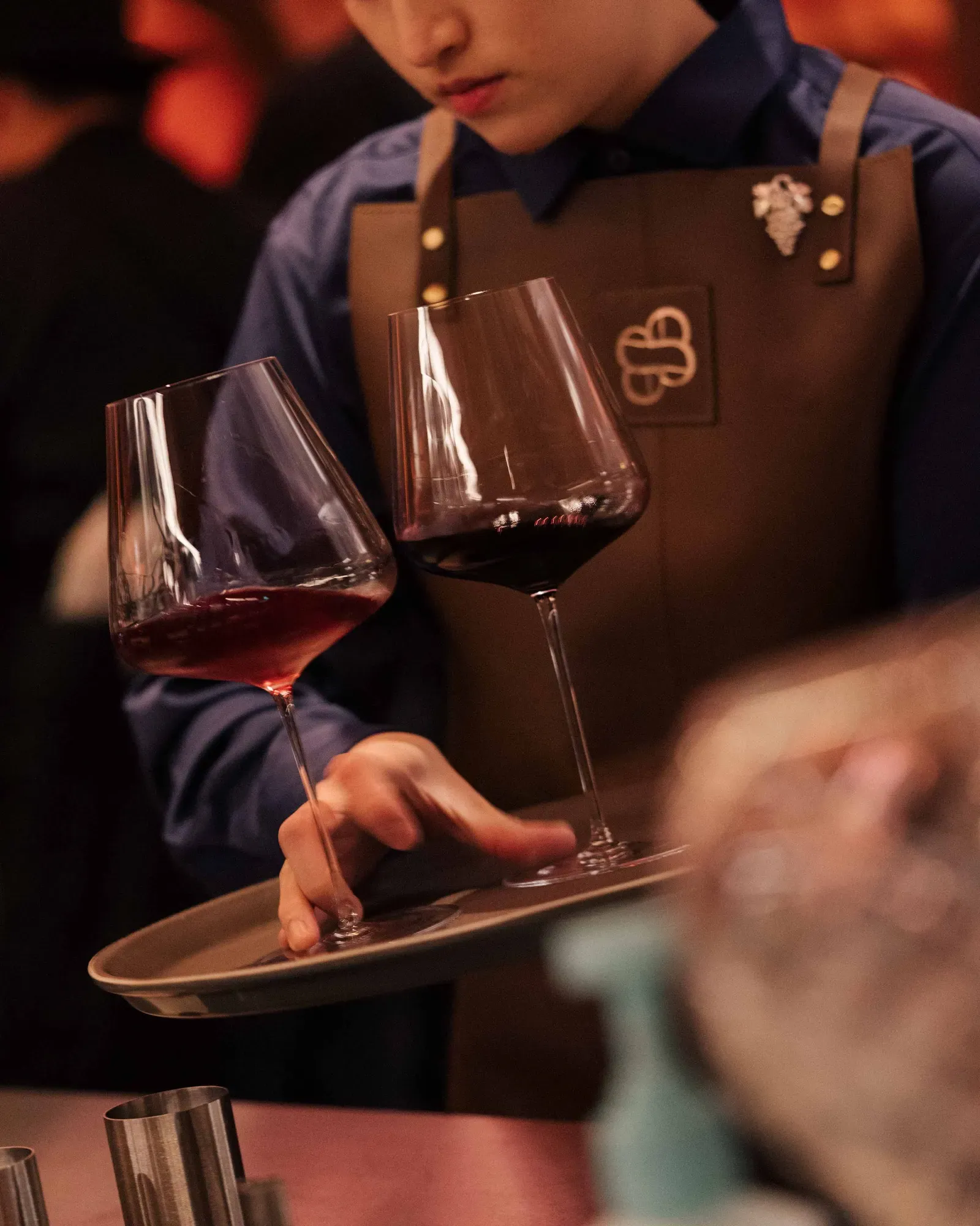 Sommelier carrying a tray of red wine